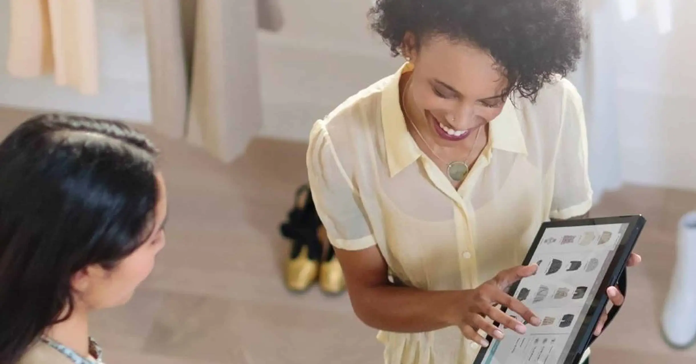 Femme montrant à une autre femme l'écran de sa tablette tactile